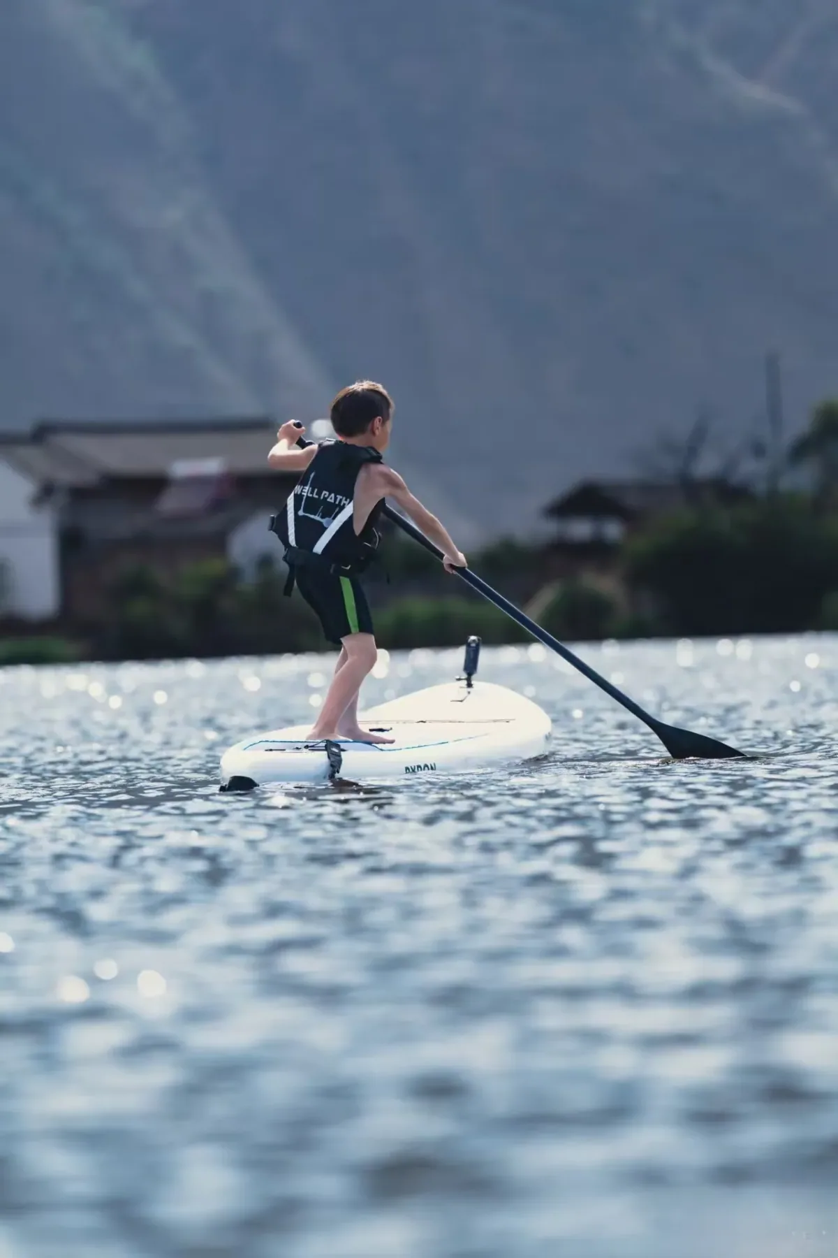 Medusa Glow SUP board packed with travel backpack by the shore